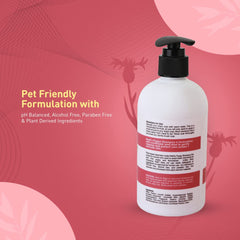 White bottle with black pump on a pink background, featuring text about pet-friendly formulation.