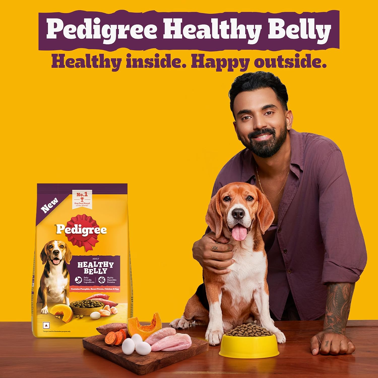 Pedigree Healthy Belly dog food advertisement featuring a man holding a beagle and a bag of Pedigree Healthy Belly dog food on a wooden table against a bright yellow background.